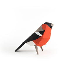 A geometric, low-poly bird sculpture made from colored paper, standing on a white background.